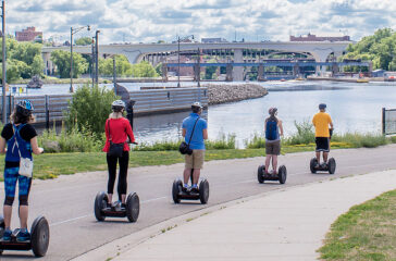 People are riding Segway along Mississippi River