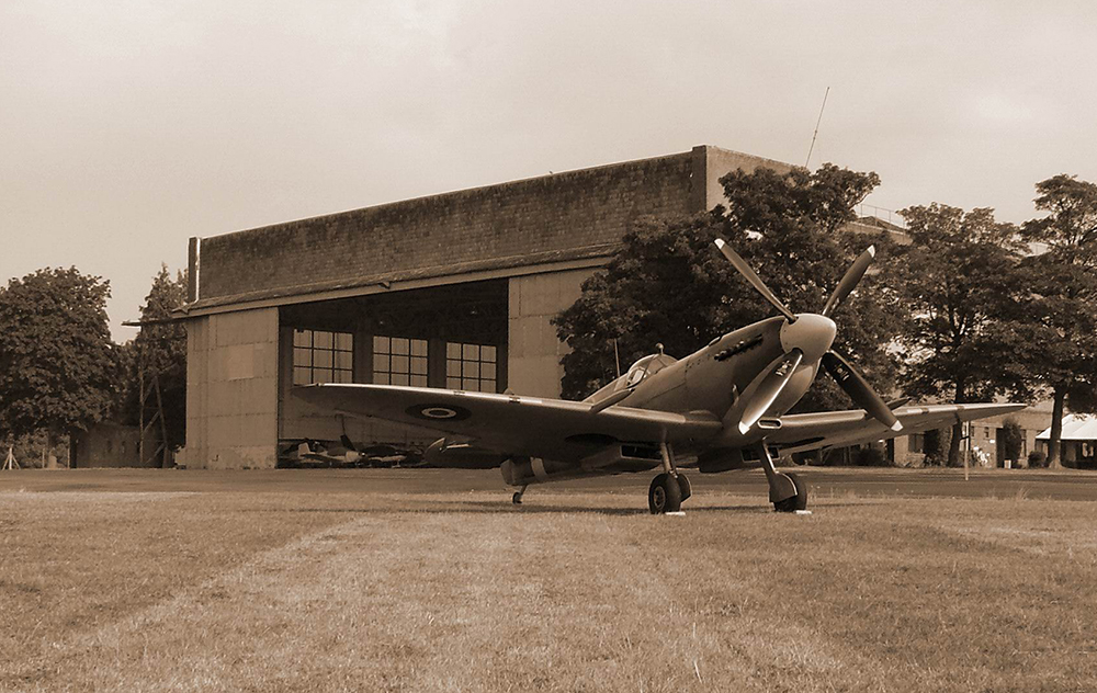 Eine Spitfire vor einem Hangar.