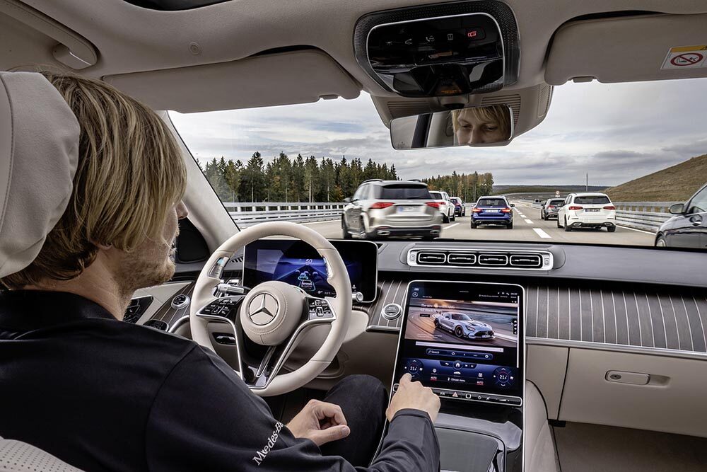 Während der hochautomatisierten Fahrt, ermöglicht DRIVE PILOT dem Fahrer sich vom Verkehrsgeschehen ab- und bestimmten Nebentätigkeiten zu zuwenden. Zum Beispiel mit den Kollegen via In-Car-Office zu kommunizieren, Mails zu schreiben, im Internet zu surfen oder entspannt einen Film anzuschauen. During the conditionally automated journey, DRIVE PILOT enables the driver to move away from the traffic situation and to turn to certain secondary activities. For example, communicating with colleagues via in-car office, writing e-mails, surfing the Internet or watching a movie in a relaxed way.