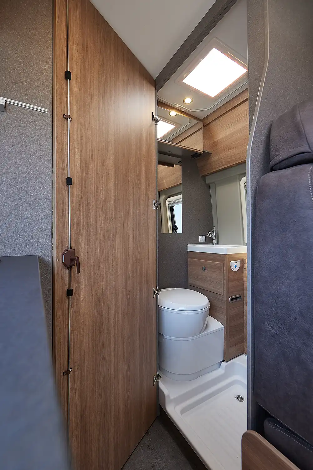 Als Festbad definiert Dethleffs eine Nasszelle mit fester Holztür, einem kleinen Waschbecken und Toilette; mit einem umlaufenden Vorhang kann der Innenraum auch zum Duschen genutzt werden.