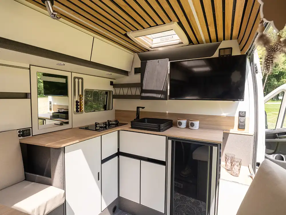 Der Weinsberg CaraLife 630LG mit Küche und TV-Gerät.