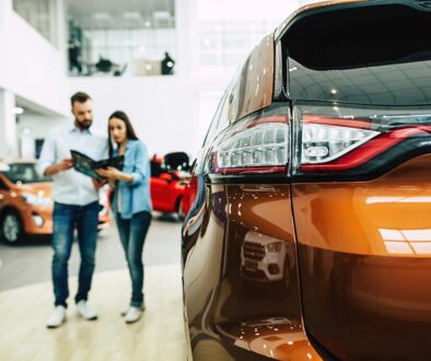 Young couple buying a new car in dealership