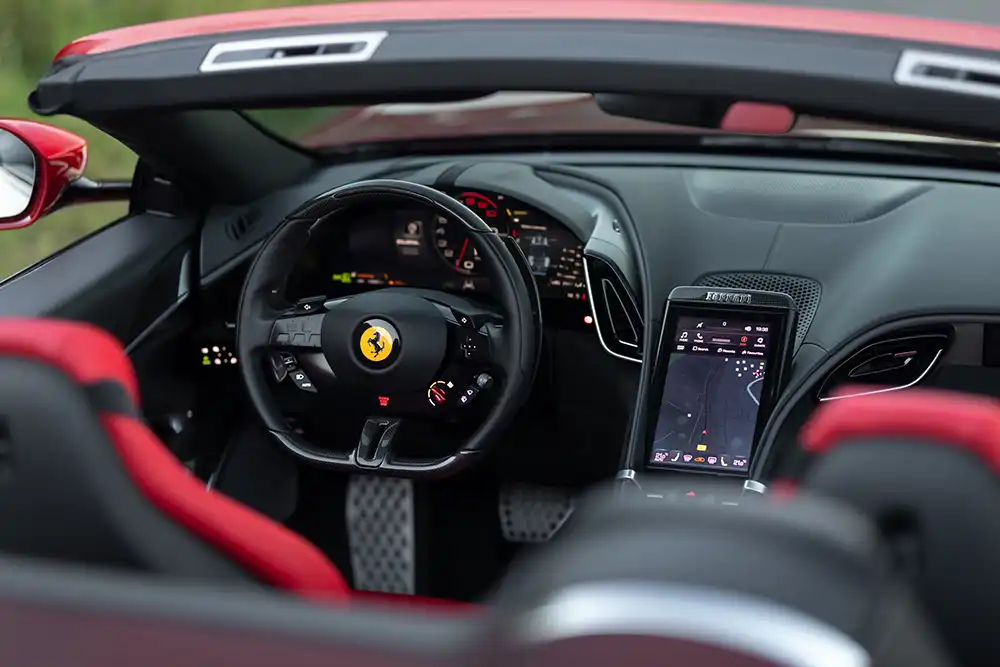 Auch das Cockpit des Ferrari Roma Spider präsentiert sich in zeitgemäßer Weise digital. Der sportlich eingerichtete Arbeitsplatz bietet zudem viele edle Materialien.