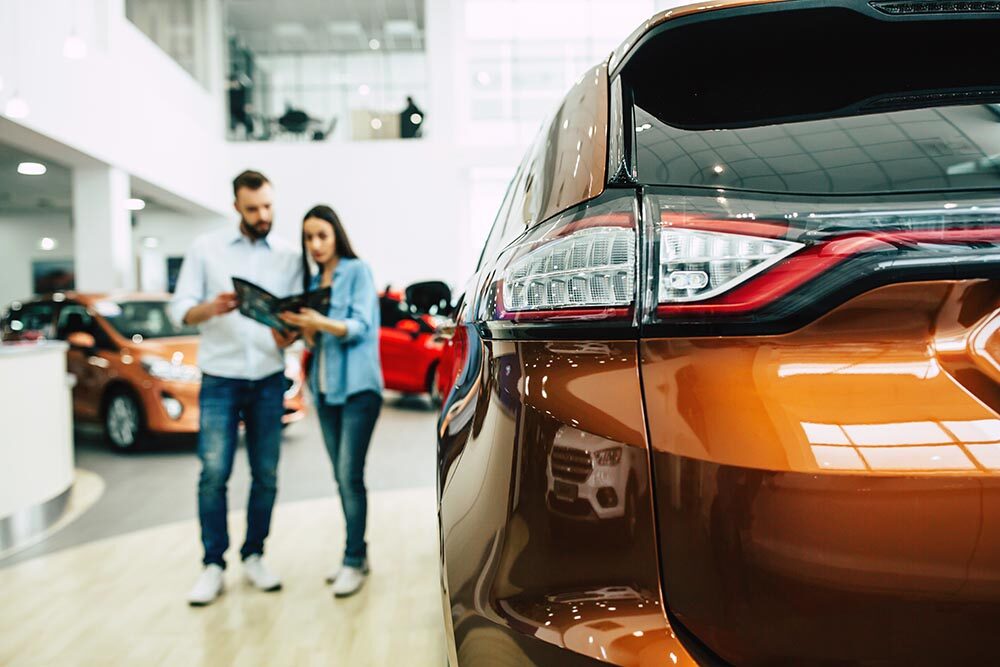 Young couple buying a new car in dealership. Titelbild: My Ocean studio - stock.adobe.com