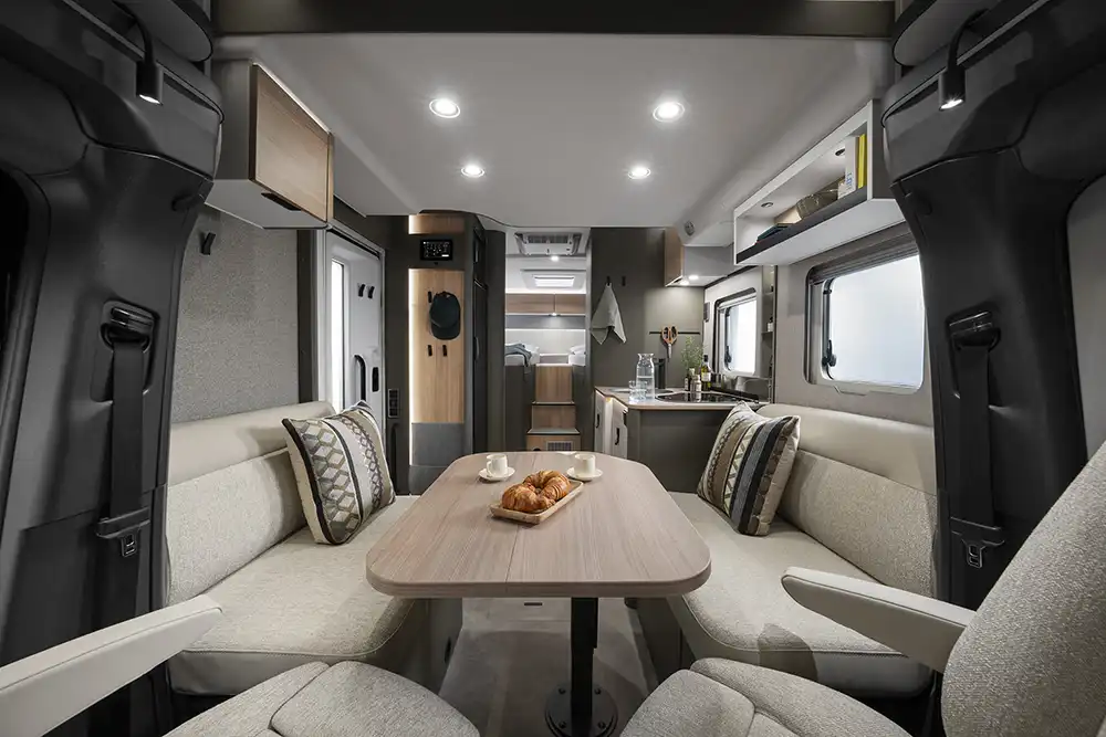 Innen gibt es Einzelbetten im Heck, die große Heckgarage, ein durchgängig ebener Boden, über zwei Meter Stehhöhe, eine Stilwelt mit Holzakzenten und matten Olivtönen sowie ein Boden in Betonoptik. Foto: Hymer