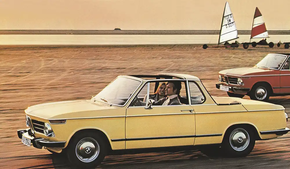 Kostspieliger Frischluftspaß für vier – Das vom Karossier Baur gebaute BMW 2002 Cabriolet kombinierte 1971 ein Targadach (vorn) mit einem klassischen Verdeck (hinten). Foto: BMW AG