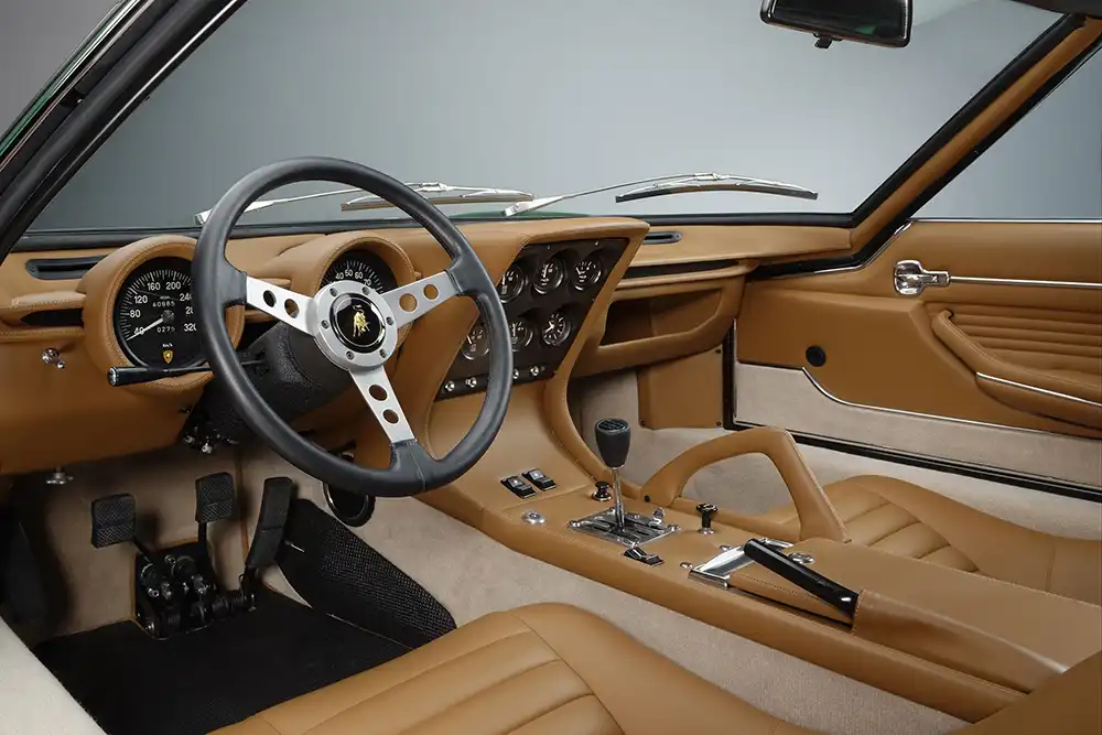 Das luxuriöse Cockpit des Miura mit braunem Leder, klassischem Dreispeichen-Sportlenkrad und der markanten Mittelkonsole.
