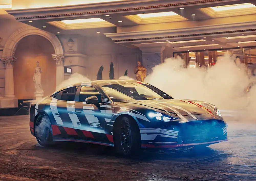 Getarnter Prototyp des vollelektrischen Mercedes-AMG GT 4-Türer bei einer spektakulären Präsentation mit Raucheffekten.