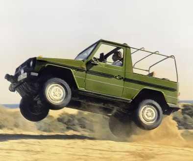 Eine grüne Mercedes G-Klasse hebt im Gelände ab – Demonstration der robusten Starrachsen-Konstruktion bei extremer Beanspruchung