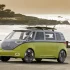 Ein lindgrüner VW ID.Buzz Concept als Elektro-Camper mit Surfbrettern auf dem Dach an der Küste – Symbol für nachhaltiges Reisen.