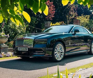 Rolls-Royce Spectre in Dunkelgrün – Das weltweit erste ultraluxuriöse Elektro-Coupé mit 584 PS in einer herrschaftlichen Einfahrt.