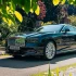 Rolls-Royce Spectre in Dunkelgrün – Das weltweit erste ultraluxuriöse Elektro-Coupé mit 584 PS in einer herrschaftlichen Einfahrt.