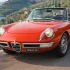 Klassischer roter Alfa Romeo Spider Duetto (Tipo 105) bei einer Ausfahrt an der italienischen Küste.