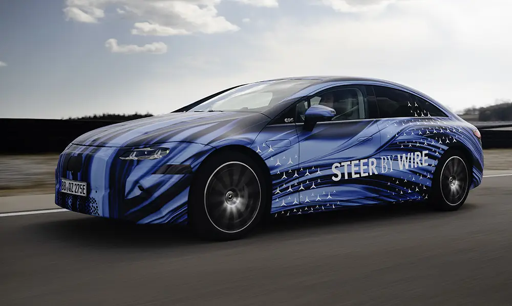 Tarnfolierter Mercedes EQS Testwagen mit Steer-by-wire Schriftzug bei einer Erprobungsfahrt auf abgesperrter Strecke. Foto: Mercedes-Benz
