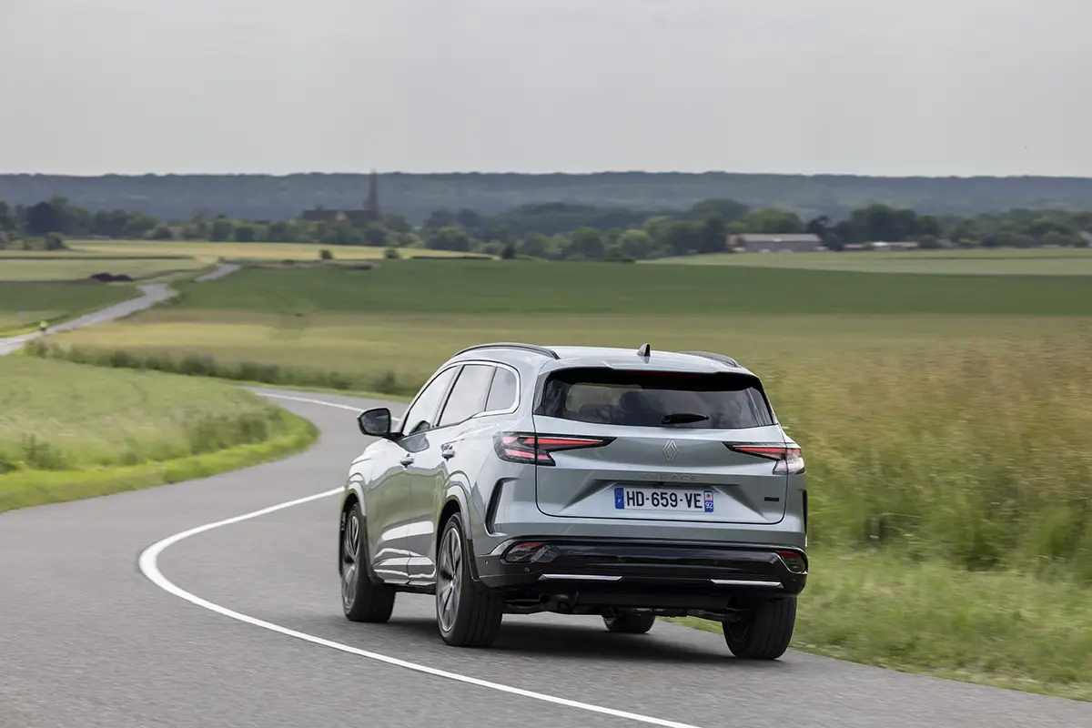 Heckansicht des Renault Espace beim Durchfahren einer Kurve, das die moderne Linienführung des Mittelklasse-SUV zeigt.