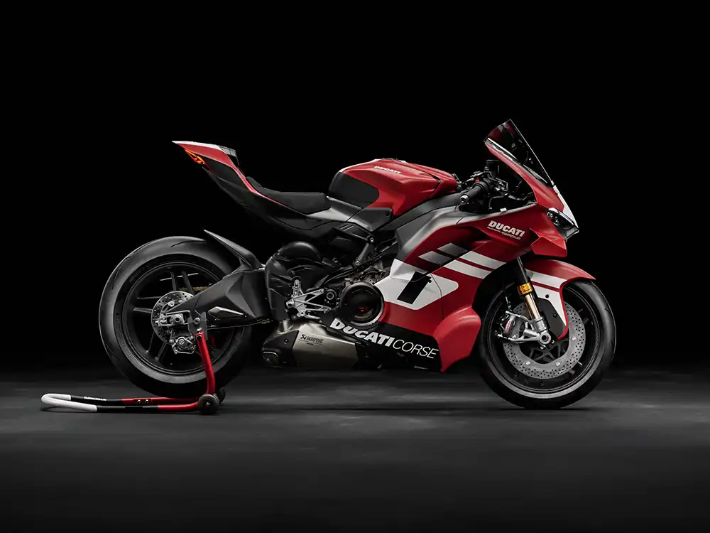 Seitenprofil der limitierten Ducati Superleggera V4 Centenario in Rot-Weiss mit Carbon-Rahmen und Akrapovič-Abgasanlage auf einem Montageständer.