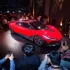 Die feuerrote Nebula Next 01 Concept Jet Edition bei der Weltpremiere in San Francisco, präsentiert auf einer Bühne vor Publikum und Medienvertretern.