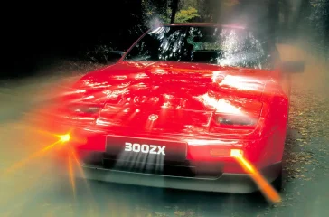 Roter Nissan 300ZX Turbo von 1986 in Fahrt, ein Symbol der japanischen Sportwagen-Offensive.