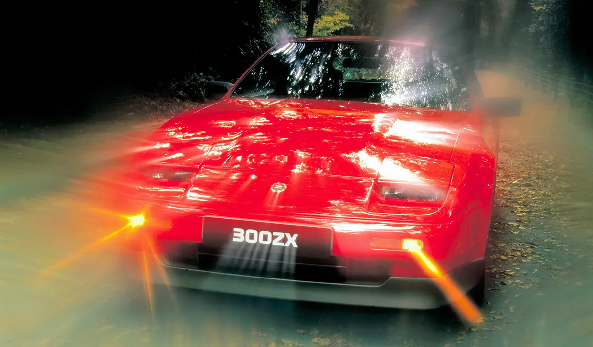 Roter Nissan 300ZX Turbo von 1986 in Fahrt, ein Symbol der japanischen Sportwagen-Offensive.