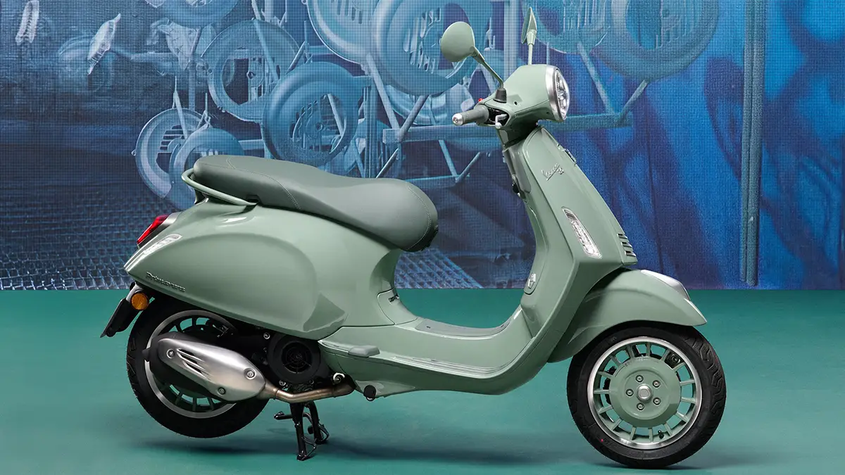 Die detaillierte Seitenansicht der pastellgrünen Jubiläums-Vespa mit farblich perfekt abgestimmten Außenspiegeln, Felgen und dem edlen dunklen Sattel.