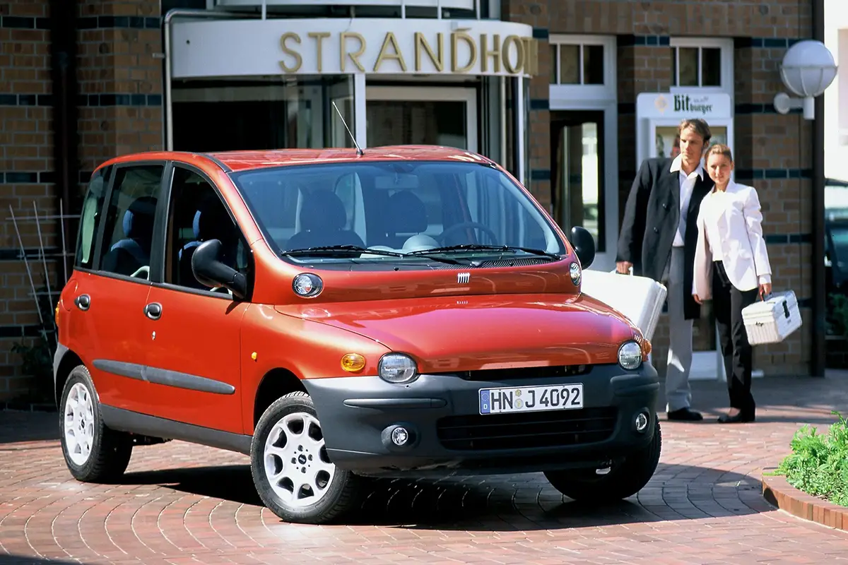 Ein roter Fiat Multipla der ersten Generation aus dem Jahr 1999, der trotz seines umstrittenen Rufs mit zwei übereinandergestapelten Lichtleisten als echtes Familien-Raumwunder überzeugte.