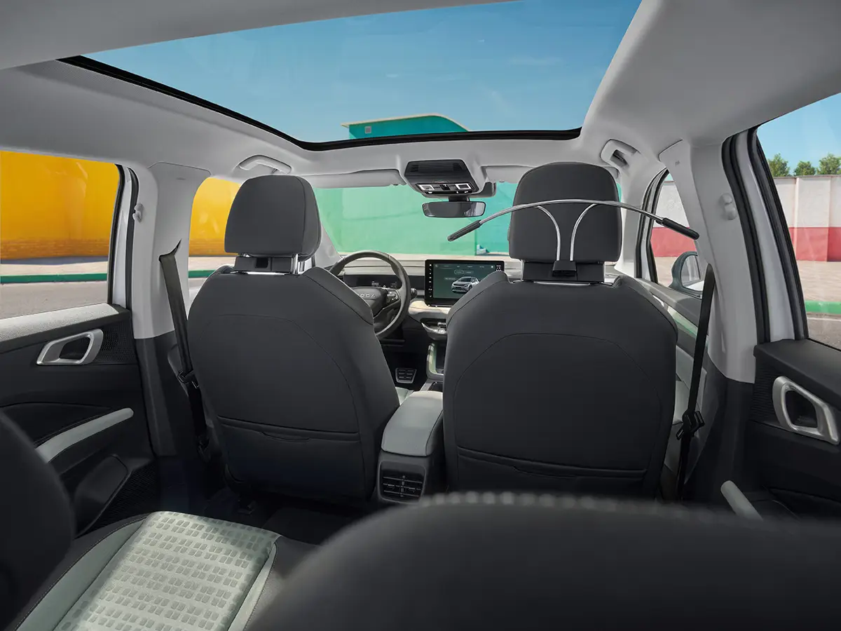 Innenraum-Perspektive von den Rücksitzen nach vorne, die das helle Ambiente unter dem großen Panorama-Glasdach des Skoda Epiq hervorhebt.