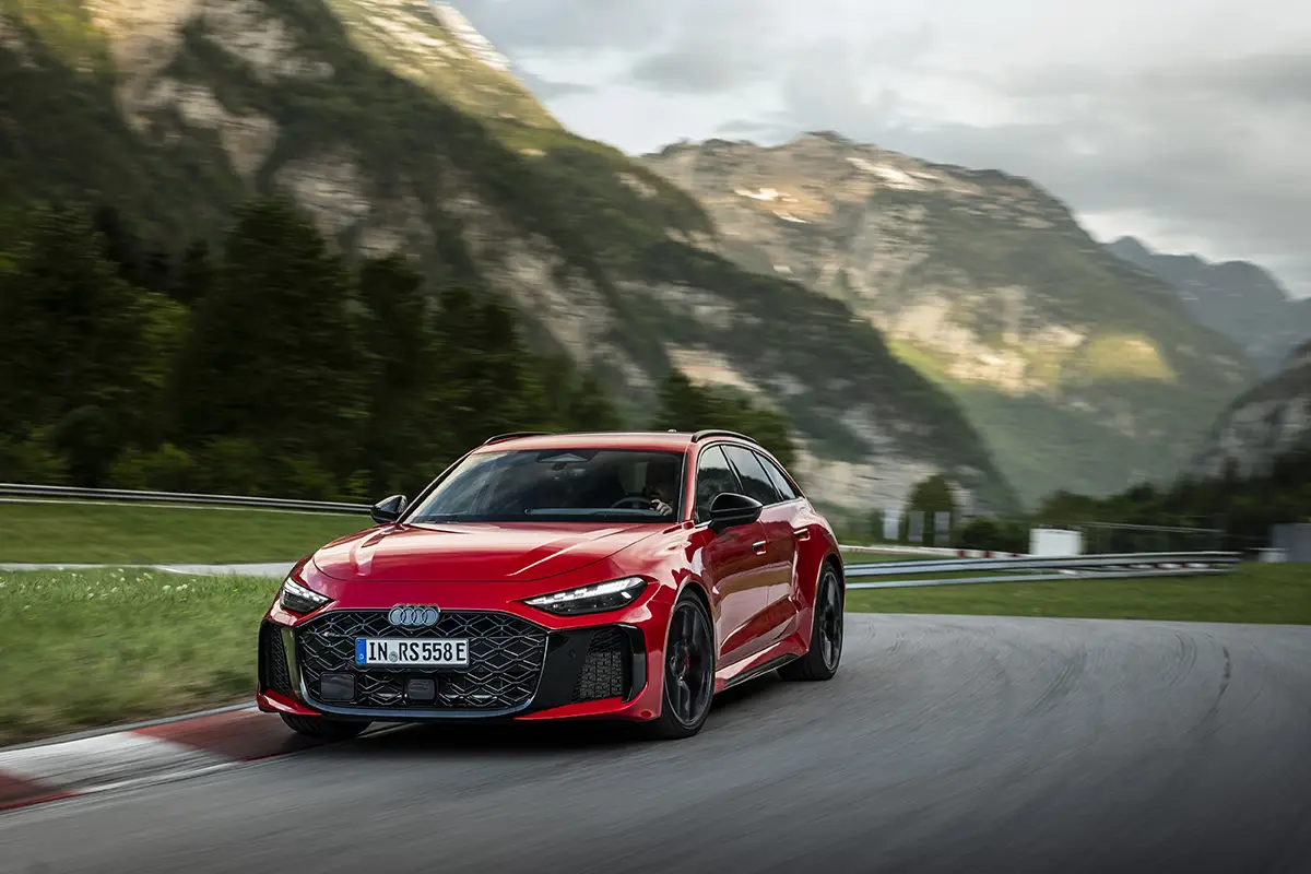 Ein roter Audi RS 5 Avant auf einer Rennstrecke vor einer malerischen Bergkulisse in Saalfelden.