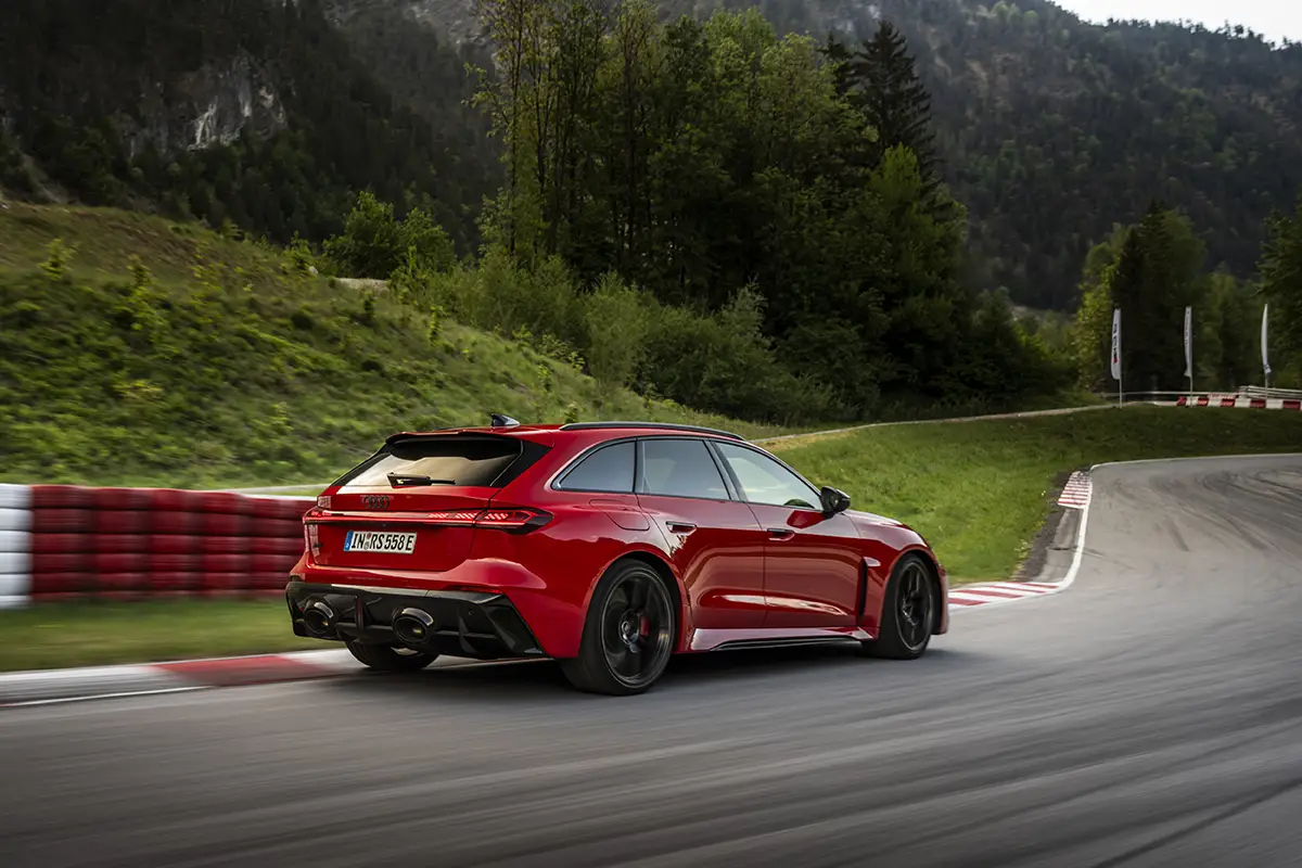 Die Heckansicht des roten Audi RS 5 Avant in einer Kurve mit markantem Diffusor und den zwei gewaltigen Endrohren der RS-Sportabgasanlage.