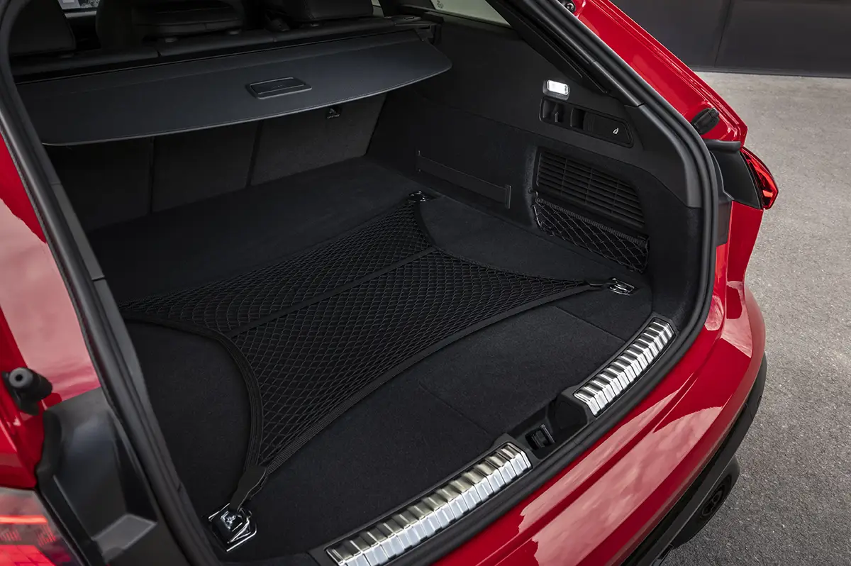 Der geöffnete, ebene Kofferraum des roten Audi RS 5 Avant zur Veranschaulichung des praktischen Ladevolumens.
