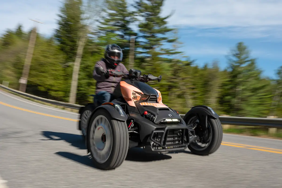 Der Can-Am Ryker Rally aus einer tiefen Perspektive von vorne auf der Straße, um den bulligen Bug und die durchgehende Lenkstange zu inszenieren.