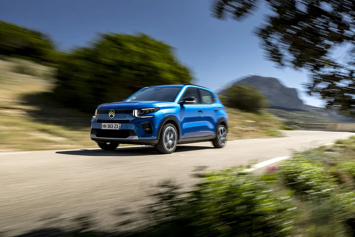Blauer Citroën ë-C3 als preiswertes Elektro-Leichtfahrzeug auf einer Landstraße.