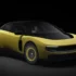 Dreiviertel-Frontansicht des neuen Ferrari Luce in sportlichem Gelb-Gold mit abgedunkeltem Glasdach und aerodynamischen Felgeneinsätzen vor dunklem Hintergrund.