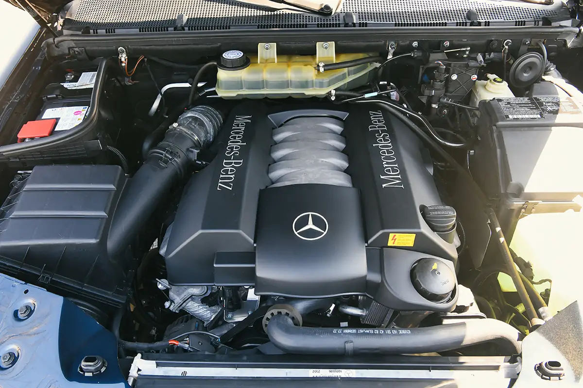 Blick unter die geöffnete Motorhaube auf den kraftvollen V8-Motor eines Mercedes-Benz ML 500 mit sichtbarem Markenlogo.
