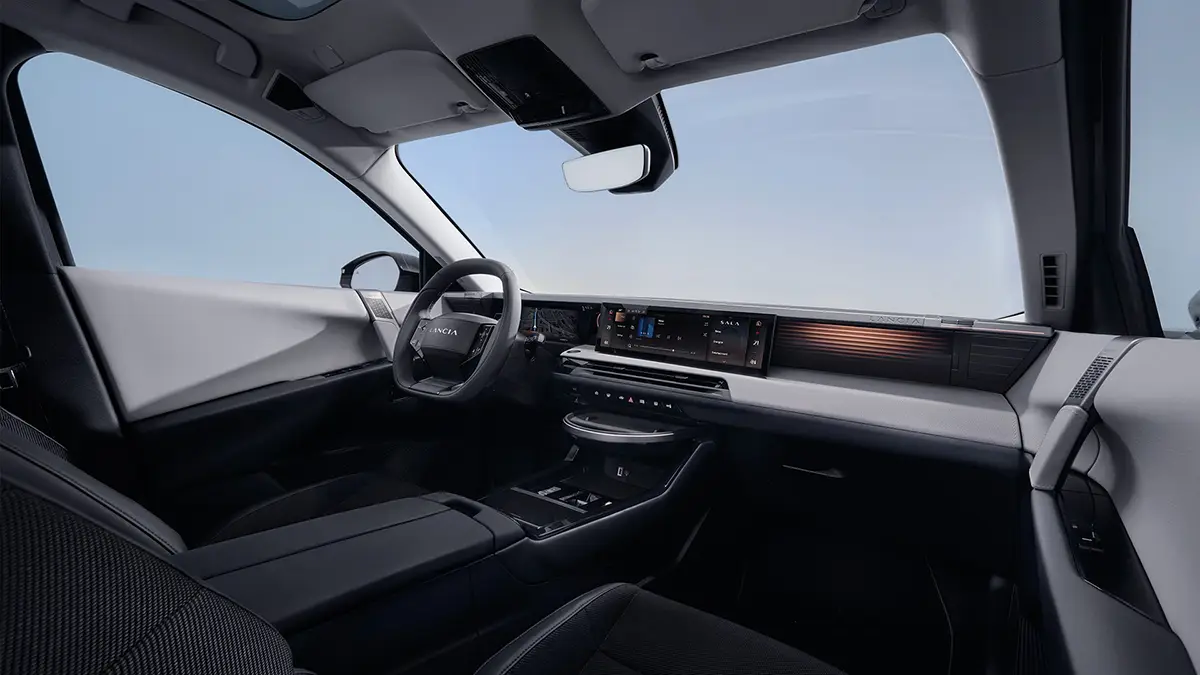 Der modern eingerichtete Innenraum des Lancia Gamma mit Blick auf das minimalistische Cockpit, das breite digitale Display-Band und die Mittelkonsole.
