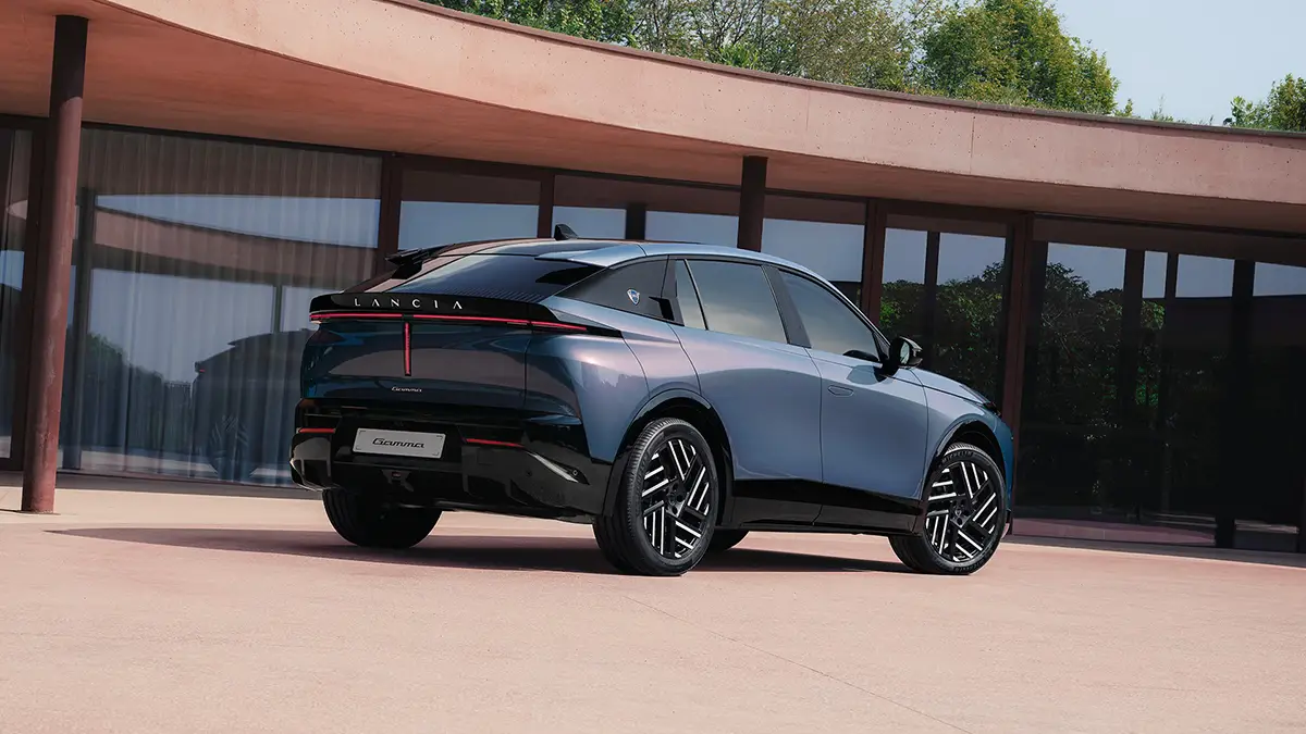 Die Heckansicht des neuen, modernen Lancia Gamma SUV-Flaggschiffs im modischen Crossover-Dress vor einer minimalistischen Architekturkulisse.
