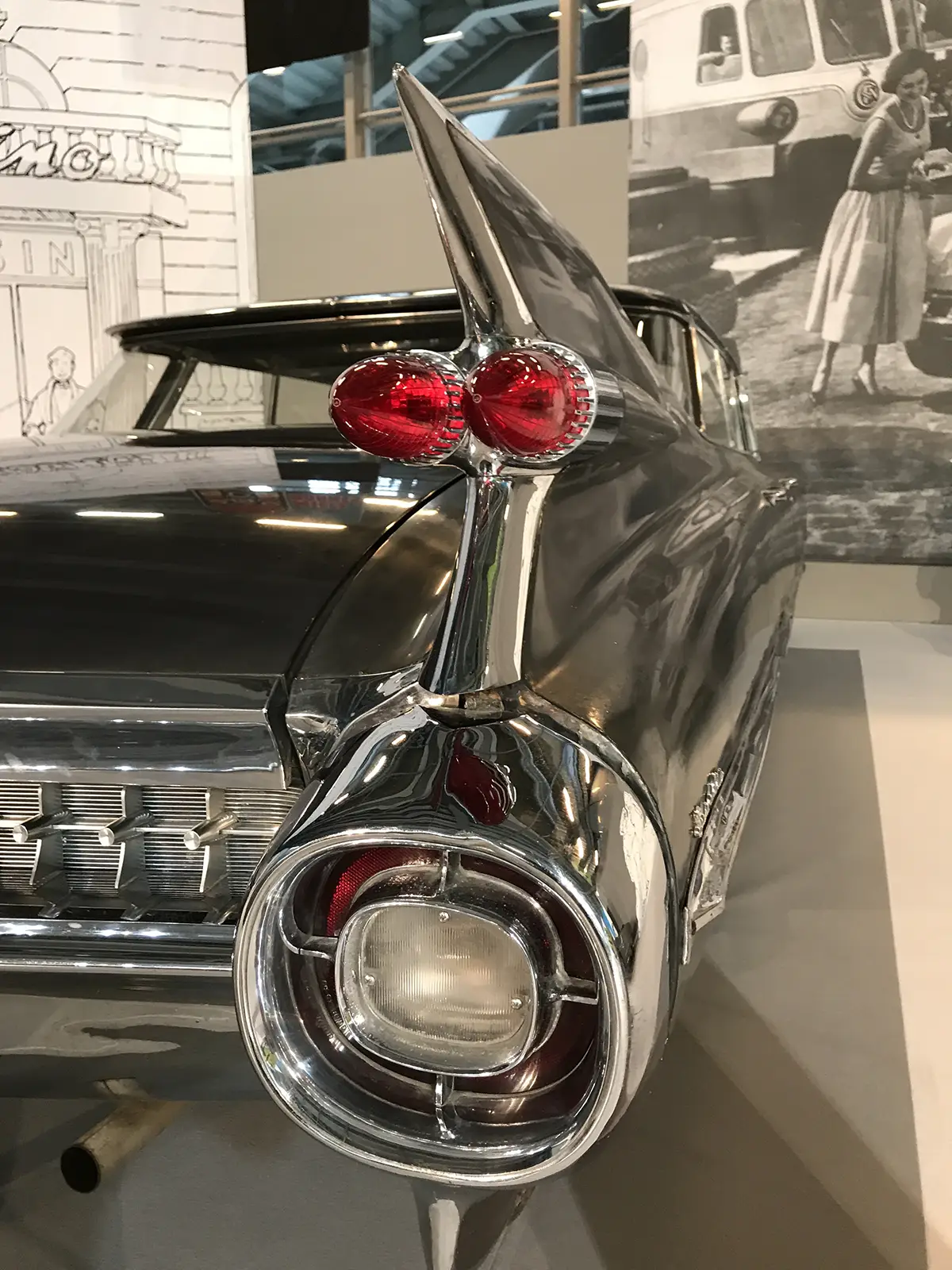 Heckansicht eines schwarzen 1959er Cadillac Type Sixty-Two, dessen rund einen Meter hohe, messerscharfe Heckflossen mit raketenartigen Doppelleuchten das Space-Age-Design markieren.
