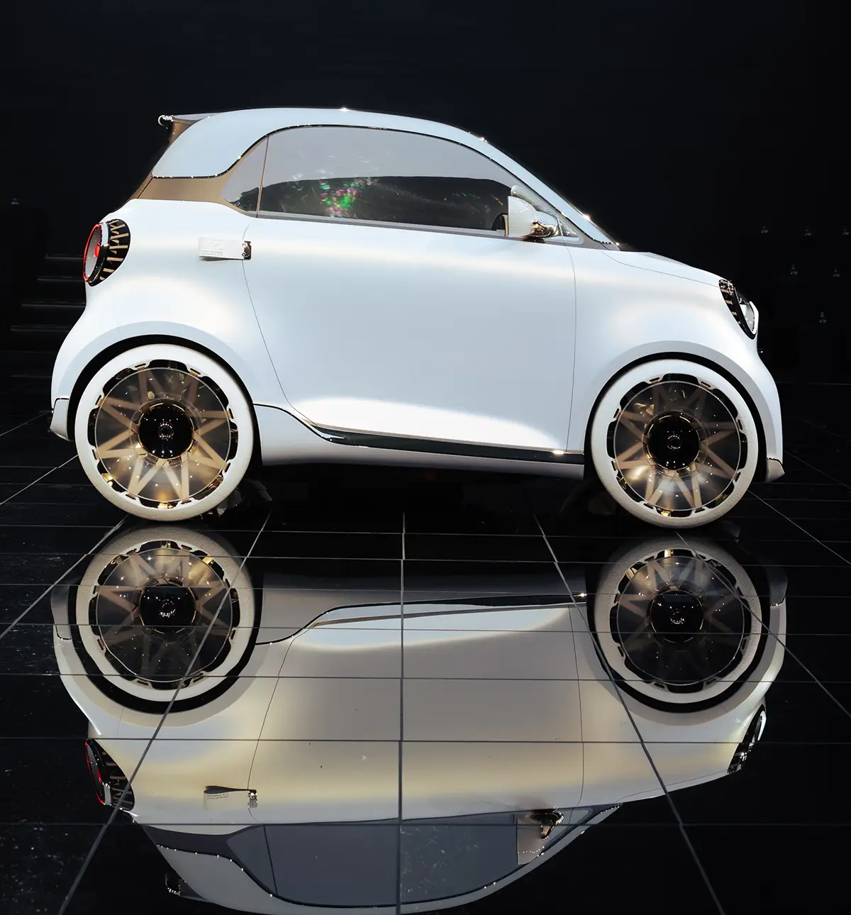 Die kompakte Silhouette des Smart #2 in der Seitenansicht, welche die markante Tridion-Zelle, ultrakurze Überhänge und die zweifarbige Karosserie zeigt.
