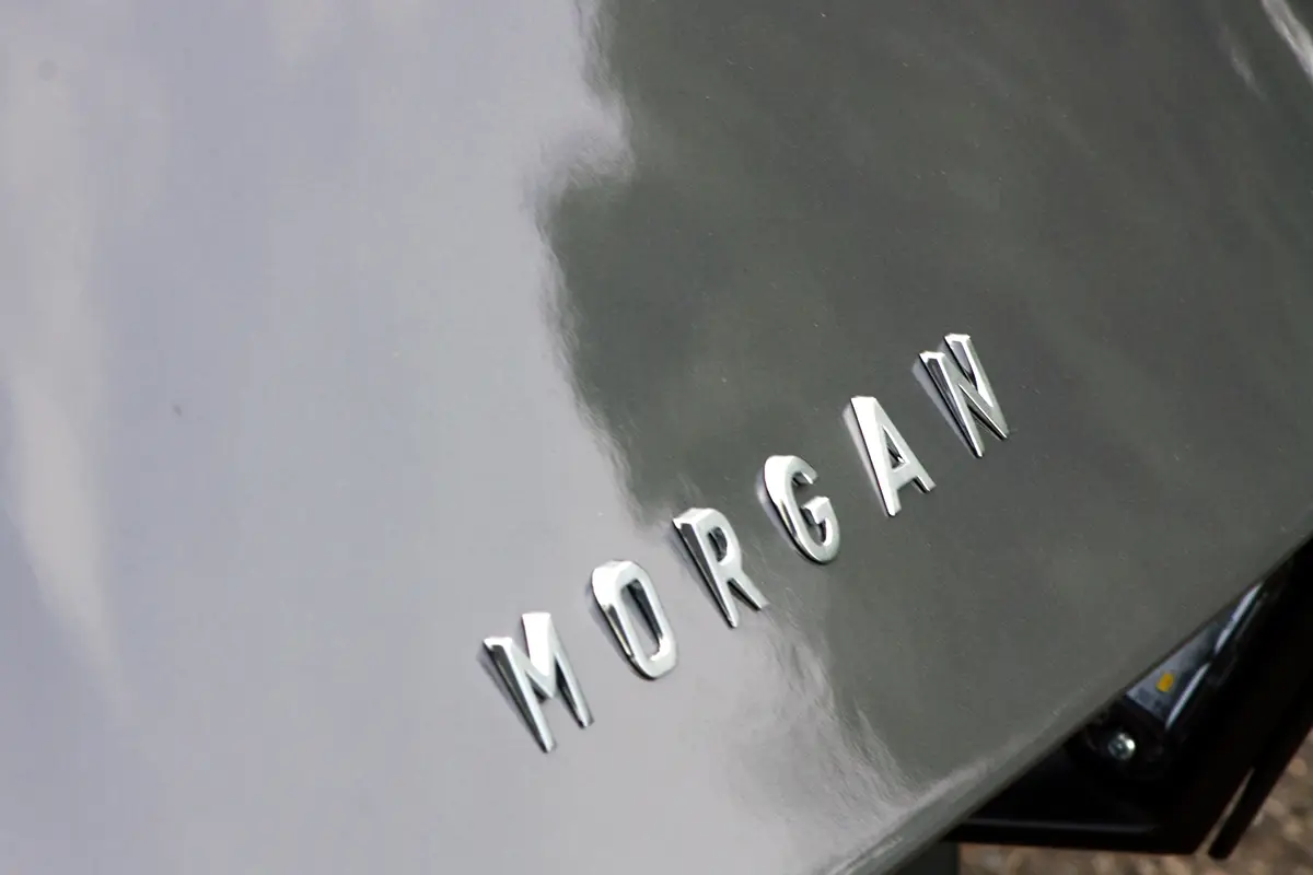 Nahaufnahme des verchromten „MORGAN“-Schriftzugs auf der polierten Motorhaube.