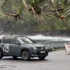 Ein grauer Renault 4 Elektro mit einer markanten weissen Startnummer 4 auf der Vordertür parkt an einer Küstenstrasse auf La Réunion im Hintergrund eines weissen Bootes mit der Aufschrift LUCKY LUKE.