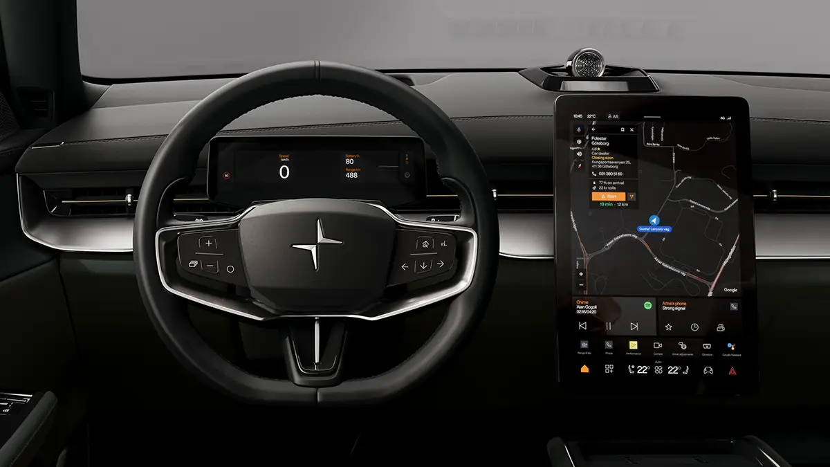 Blick auf das minimalistische, schwarze Cockpit eines Polestar-Elektrofahrzeugs mit digitalem Kombiinstrument hinter dem Dreispeichen-Lenkrad und einem großen, vertikalen Infotainment-Touchscreen, der eine aktive Navigationskarte anzeigt.