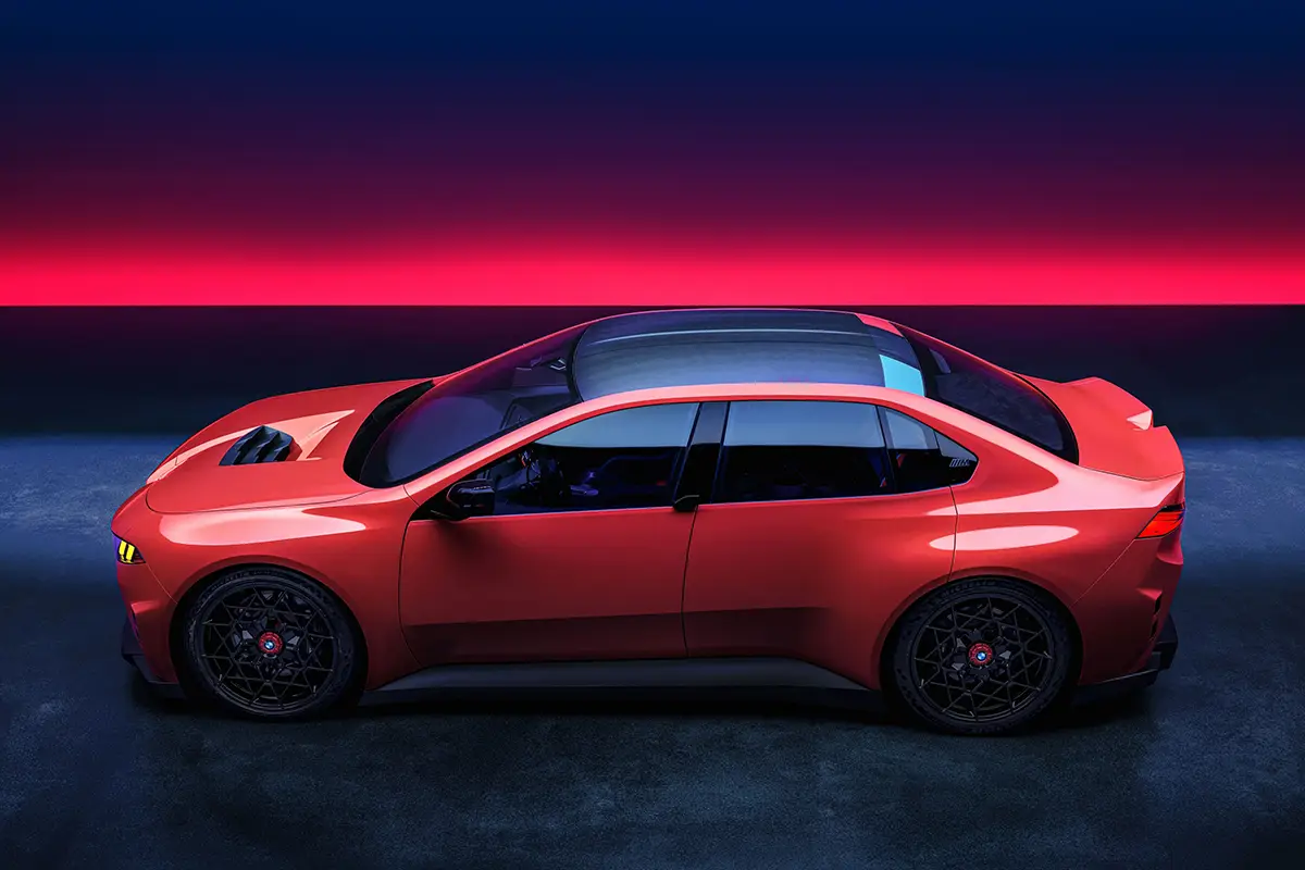 Das rote BMW M Concept Neue Klasse im Seitenprofil, das durch die Abwesenheit klassischer Türgriffe eine besonders fließende, coupéhafte Optik vermittelt.