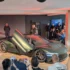Die feierliche Weltpremiere des Genesis Magma GT Concept vor Publikum in Le Mans, präsentiert auf einer Ausstellungsbühne mit weit nach oben geöffneten Flügeltüren.