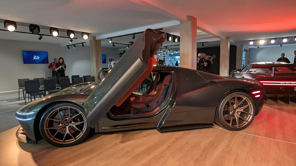 Sportliche Seitenansicht des Genesis Magma GT Concept mit spektakulär geöffneten Flügeltüren, die den Blick in den luxuriösen, rot gestalteten Innenraum freigeben