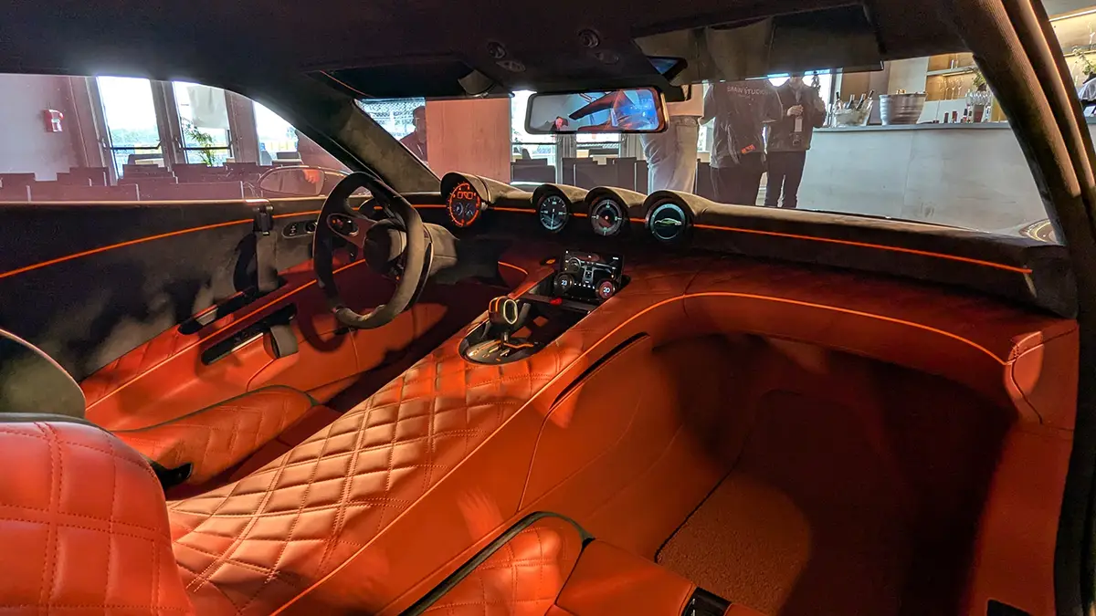 Der luxuriöse Innenraum des Genesis Magma GT mit fahrerorientiertem Twin-Cockpit-Layout und exklusiven, gesteppten Lederpolstern in hellem Rot-Orange.