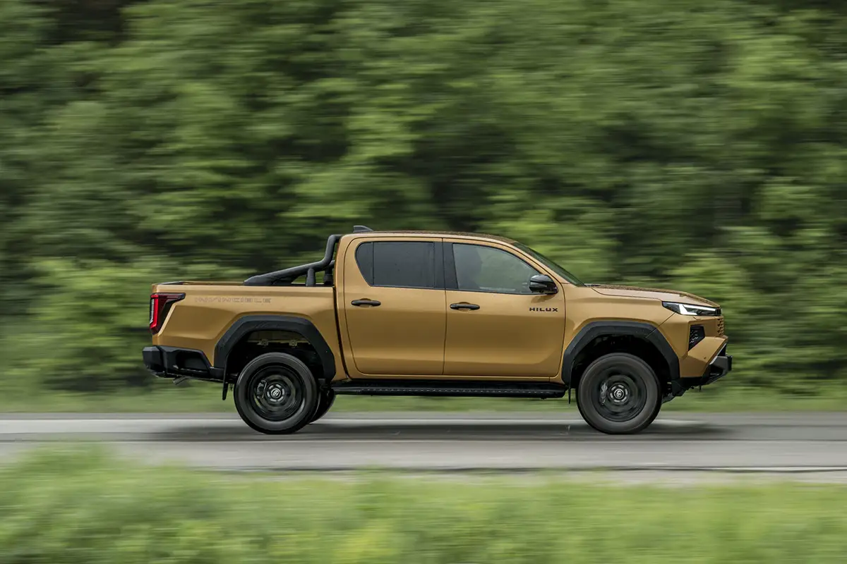 Seitenansicht des über 5,32 Meter langen Toyota Hilux Pickups in Fahrt auf freier Strecke.