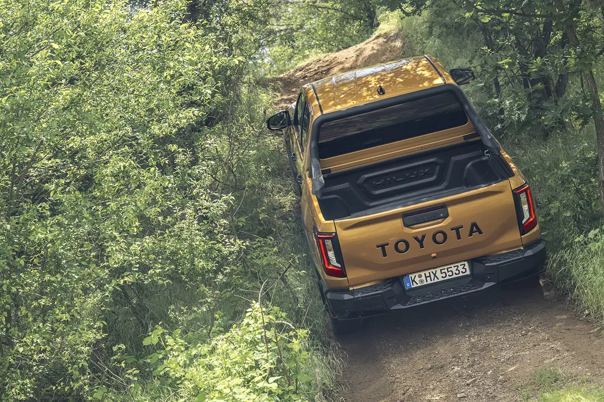 Das fahrerorientierte, robust gestaltete Cockpit des neuen Toyota Hilux mit modernisiertem Infotainment-Bildschirm und Multifunktionslenkrad.