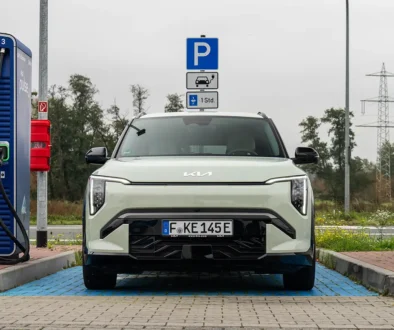 Ein weisser Kia Elektro-SUV lädt an einer öffentlichen DC-Schnellladestation von Aral Pulse auf einem ausgewiesenen E-Auto-Parkplatz.