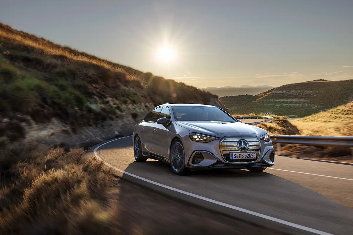 Frontseitenansicht der elektrischen Mercedes C-Klasse C 400 4Matic auf einer Passstrasse im Sonnenlicht.