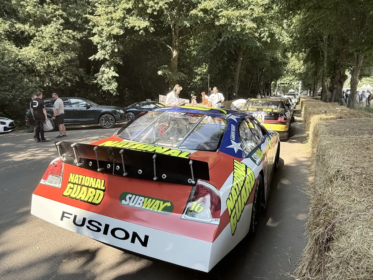 Ein farbenfrohes US-amerikanisches NASCAR-Rennfahrzeug (Ford Fusion) mit Subway- und National Guard Sponsoring auf den Zuschauerschandwegen in Goodwood.