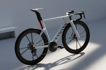 Das Konzept-Rennrad Canyon Predict in hellem Silber-Grau mit einem aerodynamisch optimierten Carbonrahmen, einer markanten integrierten Lichtleiste an der Sattelstütze und hohen Carbon-Laufrädern im Studio.
